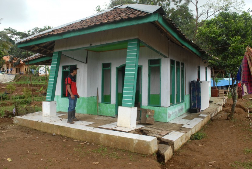 Seorang warga mengecek rumah terdampak bencana pergerakan tanah di Desa Waringinsari, Kecamatan Takokak, Cianjur, Jawa Barat, Selasa (3/10). 