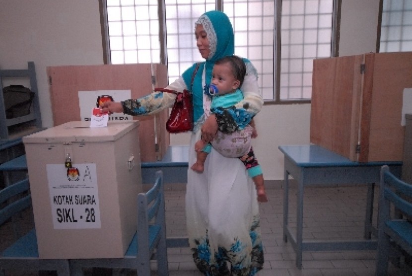 An Indonesian puts her ballot paper into a ballot box in Kuala Lumpur, Malaysia, on Sunday.