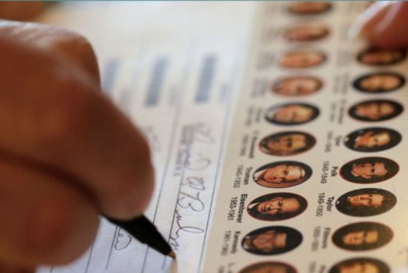 Seorang warga mengisi surat suaranya di sebuah TPS di Wellsville, Kansas (6/11). Data pendahuluan jajak pendapat nasional menunjukkan 73 persen warga AS keturunan Asia memilih Obama sebagai Presiden.