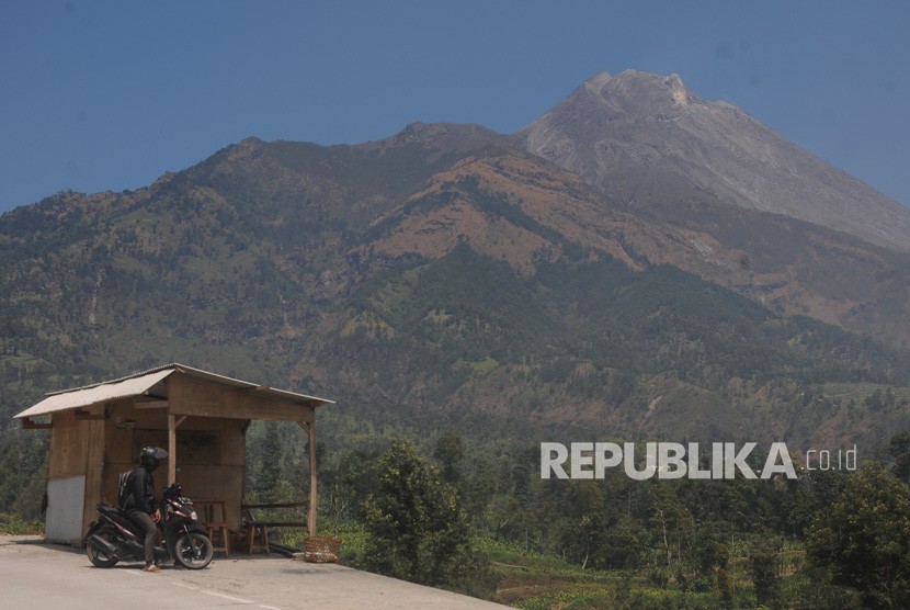 Seorang warga menikmati pemandangan Gunung Merapi di Selo, Boyolali, Jawa Tengah, Jumat (30/8/2019). 