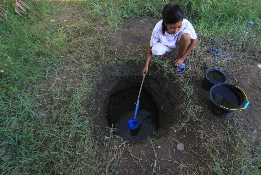 Seorang warga menimba air bersih dari sebuah lubang (ilustrasi)