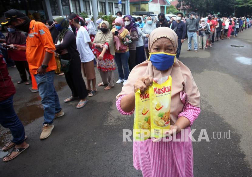 Seorang warga menunjukan minyak goreng kemasan yang dibeli saat operasi pasar minyak goreng murah di kawasan Pamulang, Kota Tangerang Selatan, Provinsi Banten, Selasa (11/1/2022).