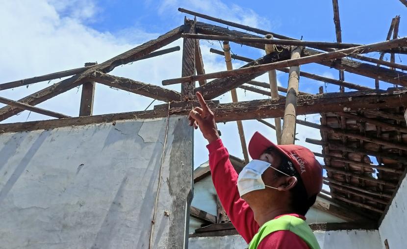 Seorang warga menunjukkan atap rumahnya yang runtuh akibat gempa di Desa Sumberrejo, Ambulu, Jember, Jawa Timur, Kamis (16/12/2021). Gempa bumi berkekuatan magnitudo 5,1 mengguncang Kabupaten Jember yang mengakibatkan belasan rumah warga rusak dan empat orang terluka. 