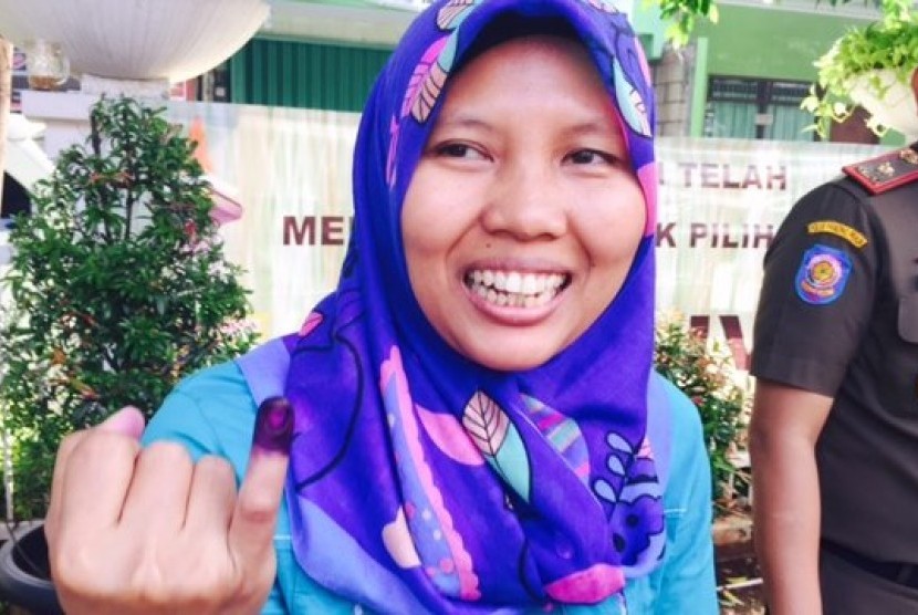 Seorang warga menunjukkan jarinya yang diberi tinta, seusai memberikan suaranya dalam Pilkada Jakarta putaran kedua, Rabu 19 April 2017.
