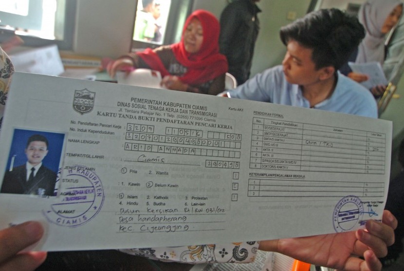 Seorang warga menunjukkan kartu AK/1 (kartu kuning) yang telah dibuatnya di kantor Dinas Ketenagakerjaan dan Transmigrasi 