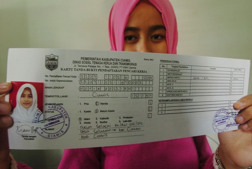 Seorang warga menunjukkan kartu AK/1 (kartu kuning) yang telah dibuatnya di kantor Dinas Ketenagakerjaan dan Transmigrasi Kabupaten Ciamis, Jawa Barat, Rabu (11/5).