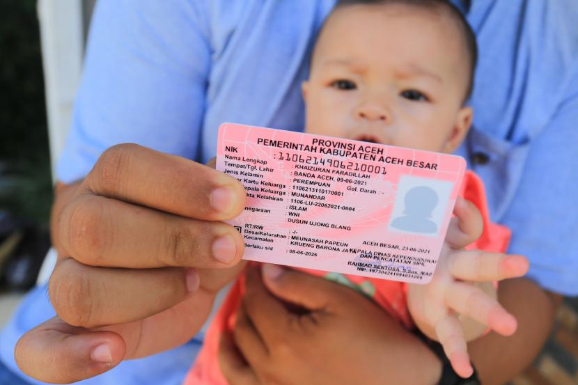 Seorang warga menunjukkan kartu identitas anak (KIA) milik anaknya (ilustrasi).