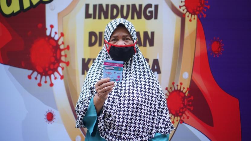Seorang warga menunjukkan kartu vaksin setelah mengikuti vaksinasi massal yang digelar Universitas Amikom di Yogyakarta, Sabtu (2/10).