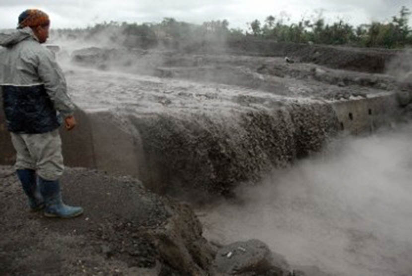 Seorang warga menyaksikan banjir lahar dingin di aliran Sungai Gendol, Bronggang, Argomulyo, Cangkringan, Sleman, Di Yogyakarta, Rabu (9/11).