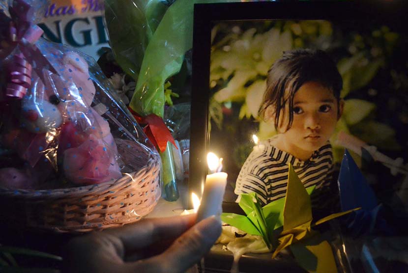 Seorang warga menyalakan lilin saat menggelar renungan untuk Angeline di depan Unit Forensik, RSUP Sanglah, Kota Denpasar, Bali. 