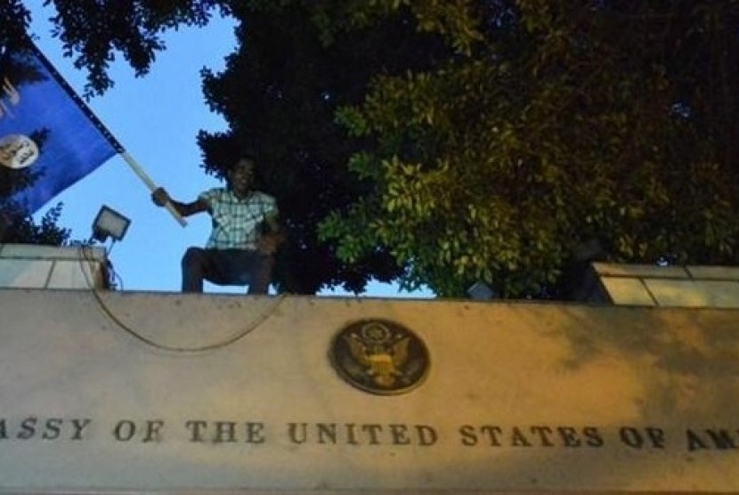 Seorang warga Mesir berdiri di atas kedutaan AS di Kairo