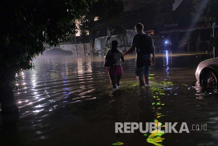 Seorang warga negara asing berjalan menembus banjir di Jalan Kemang, Ahad (28/8) dini hari. (Foto: Yogi Ardhi/Republika)