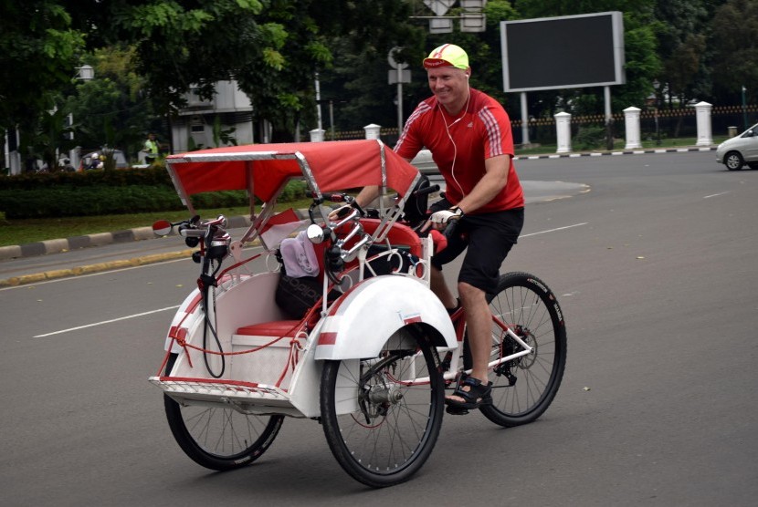 Seorang warga negara asing mengendarai becak melintasi Jalan Medan Merdeka Barat, Jakarta Pusat, beberapa waktu lalu. (ilustrasi)