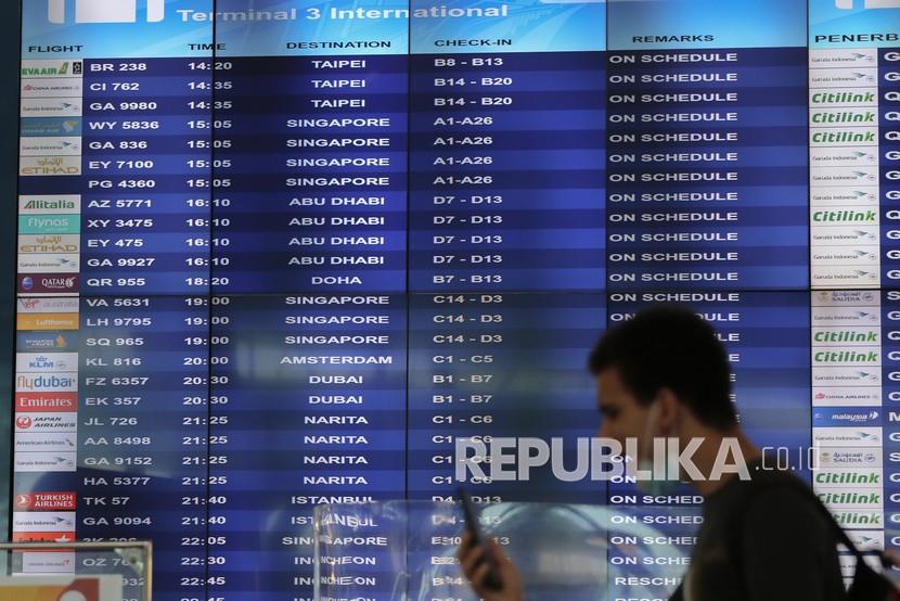 Seorang warga negara asing (WNA) berjalan di depan jadwal keberangkatan internasional di Terminal 3 Bandara Internasional Soekarno-Hatta, Tangerang, Banten. Badan Perlindungan Konsumen Nasional (BPKN) minta semua perusahaan maskapai untuk tetap menjaga kualitas layanan keselamatan, kenyamanan dan kesehatan penumpang.