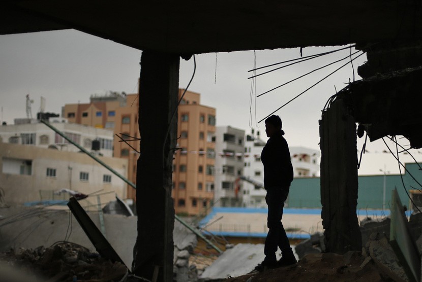  Seorang warga Palestina berdiri diatas reruntuhan stadion sepak bola, yang hancur akibat serangan udara Israel selama konflik delapan hari di Kota Gaza,Selasa (4/12).  (Reuters/Suhaib Salem)