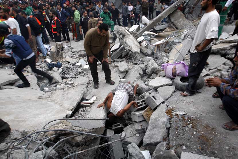   Seorang warga Palestina memeriksa reruntuhan bangunan akibat serangan udara Israel di kamp pengungsi Jebaliya sebelah Utara Jalur Gaza, Sabtu (17/11).  (AP/Hatem Moussa)