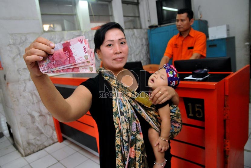  Seorang warga pemegang kartu perlindungan sosial (KPS) Bantuan Langsung Sementara Masyarakat (BLSM) di Kantor Pos Jatinegara, Jakarta Timur, Senin (2/9).   (Republika/Prayogi)