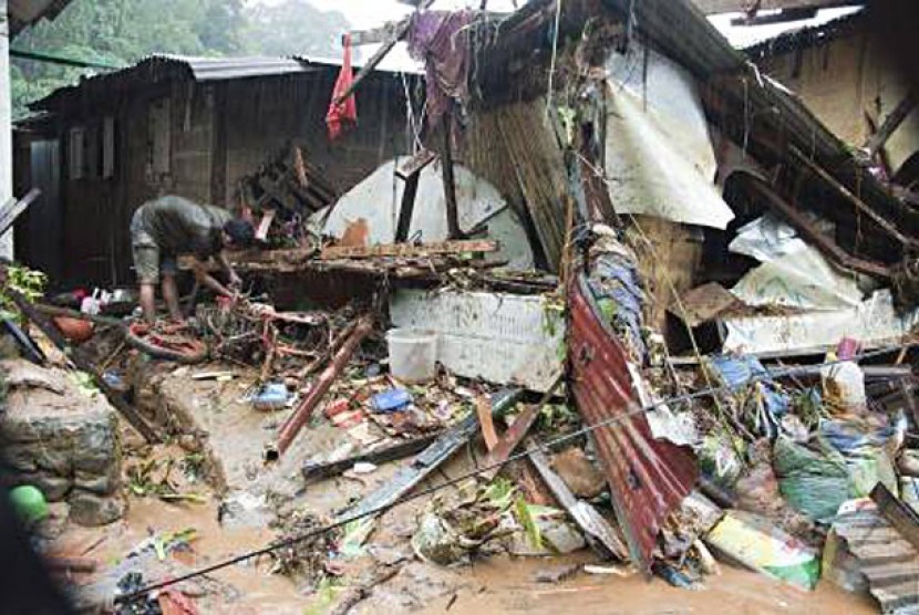 Seorang warga sedang mencoba menyelamatkan beberapa barang berharga pada bekas rumahnya yang dihantam banjir di kasasan Batu Merah Dalam, Kecamatan Sirimau, Kota Ambon, Maluku, Rabu (1/8) sore. 