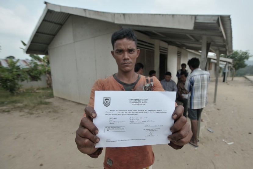 Seorang warga Suku Anak Dalam (SAD) rombong (kelompok) Hari yang sudah tercatat sebagai pemilih menunjukkan Surat Pemberitahuan Pemungutan Suara Pemilihan Rio (kepala desa) usai diterima dari Ketua Kelompok Penyelenggara Pemungutan Suara (KPPS) setempat di permukiman Dwi Karya Bhakti, Pelepat, Bungo, Jambi, Selasa (24/7). 