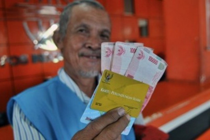 Seorang warga, Suyatno, 58 tahun, memperlihatkan Kartu Perlindungan Sosial (KPS) dan uang Bantuan Langsung Sementara Masyarakat (BLSM) sebesar Rp300 ribu untuk jangka dua bulan yang telah diambil di Kantor Pos Semarang, Jateng, Sabtu (22/6)