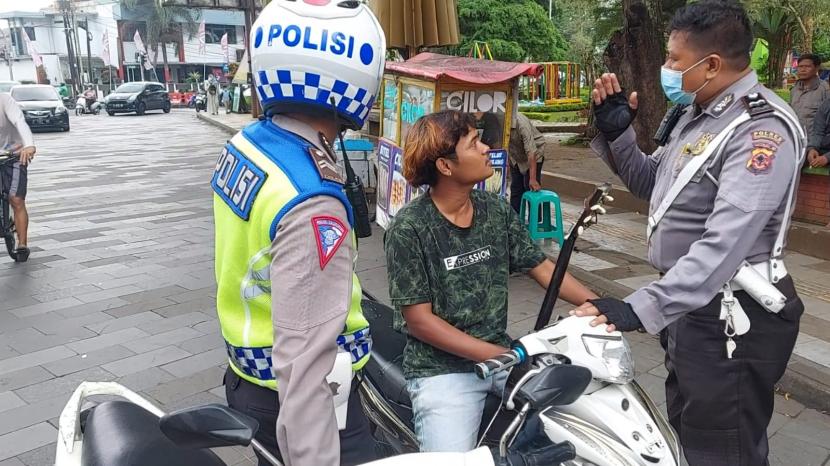 Seorang warga tak terima ketika hendak ditilang polisi saat melintas mengendarai sepeda motor di jalan raya depan Masjid Agung Kota Tasikmalaya, Jumat (22/7/2022). 