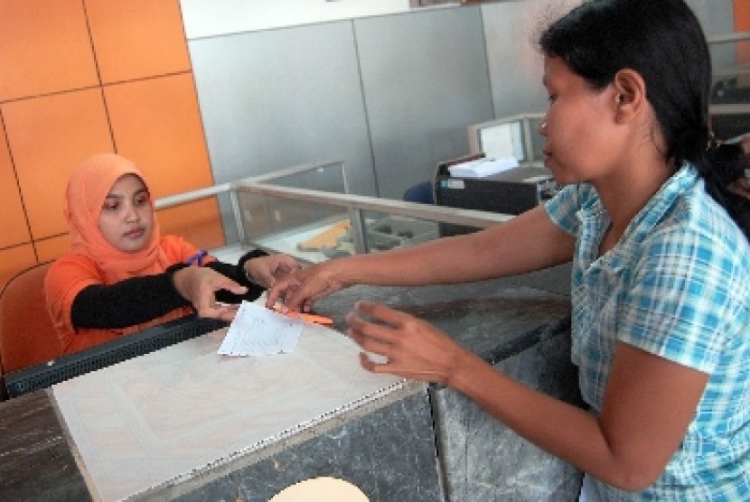 Seorang warga tengah mengambil kiriman uang di Kantor Pos (ilustrasi).