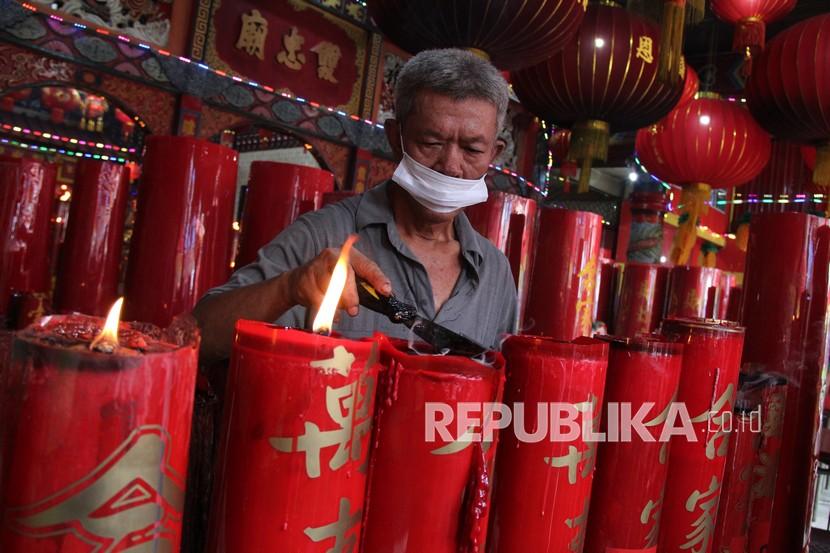 Seorang warga Tionghoa membersihkan lilin sembahyang di Kelenteng Tri Dharma Dwi Dharma Bhakti, di Pontianak, Kalimantan Barat, Senin (14/2/2022). Kegiatan tersebut sebagai persiapan untuk mengakhiri masa perayaan Tahun Baru Imlek dan menyambut Cap Go Meh yang jatuh pada Selasa (15/2/2022).