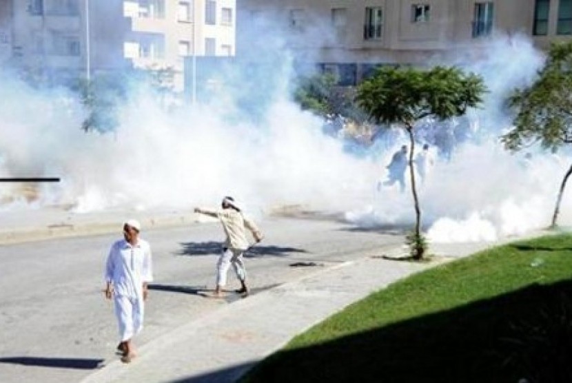 Seorang warga Tunisia melempar batu dalam aksi protes di depan Kedutaan Besar AS di Tunis, Jumat (14/9/2012)