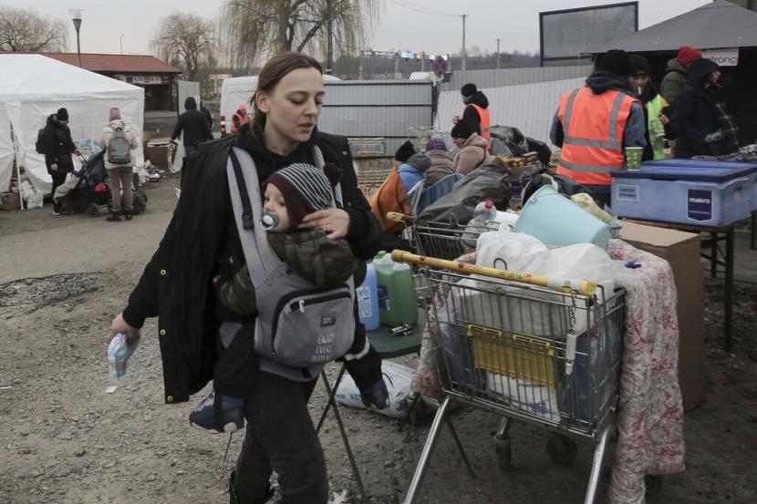 Seorang warga Ukraina bersama bayinya melintas di perbatasan di Medyka, Polandia, Kamis (3/3/2022).