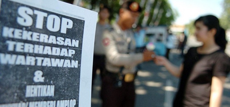 Seorang wartawan membagi-bagikan bunga kepada aparat kepolisian saat melakukan aksi bersama puluhan wartawan lainnya dalam rangka memperingati Hari Pers se-Dunia di Monumen Mandala Makassar, Sabtu (3/5). Dalam aksinya, mereka menuntut dihentikan segala ben