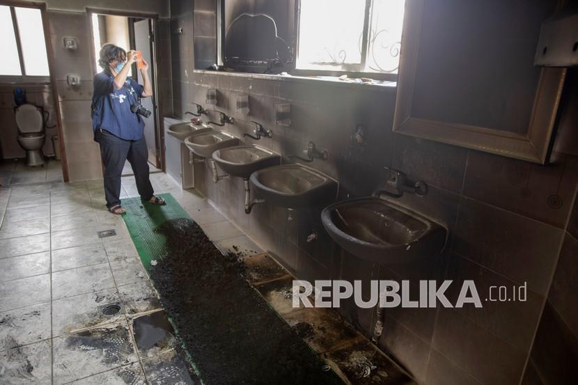 Seorang wartawan memotret kamar mandi masjid yang sebagian terbakar di el-Bireh, dekat kota Ramallah, Tepi Barat, Senin (27/7/2020).