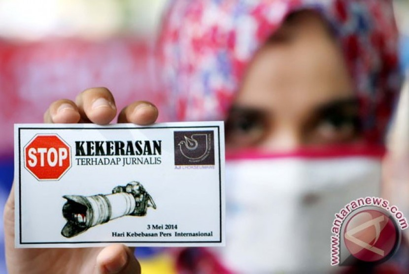 Seorang wartawan memperlihatkan striker Stop Kekerasan Terhadap Jurnalis