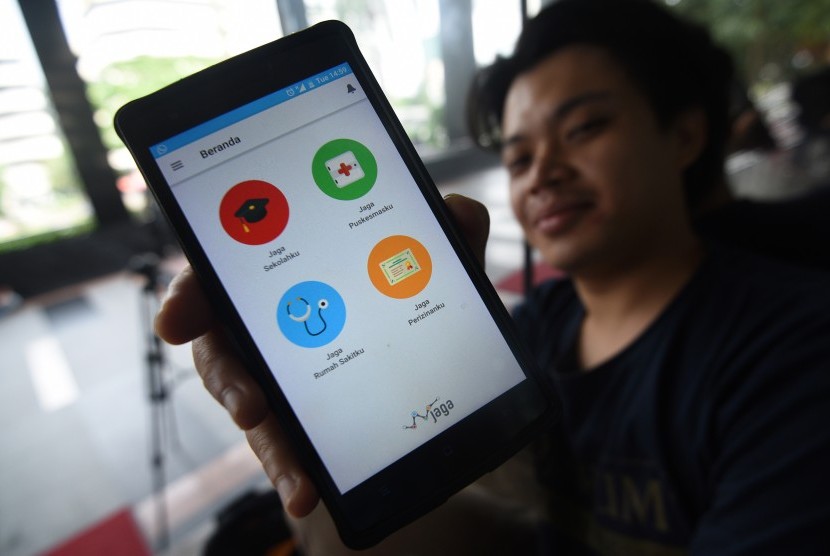 Seorang wartawan menunjukkan aplikasi JAGA yang dikembangkan KPK di Gedung KPK, Jakarta, Selasa (15/11). 