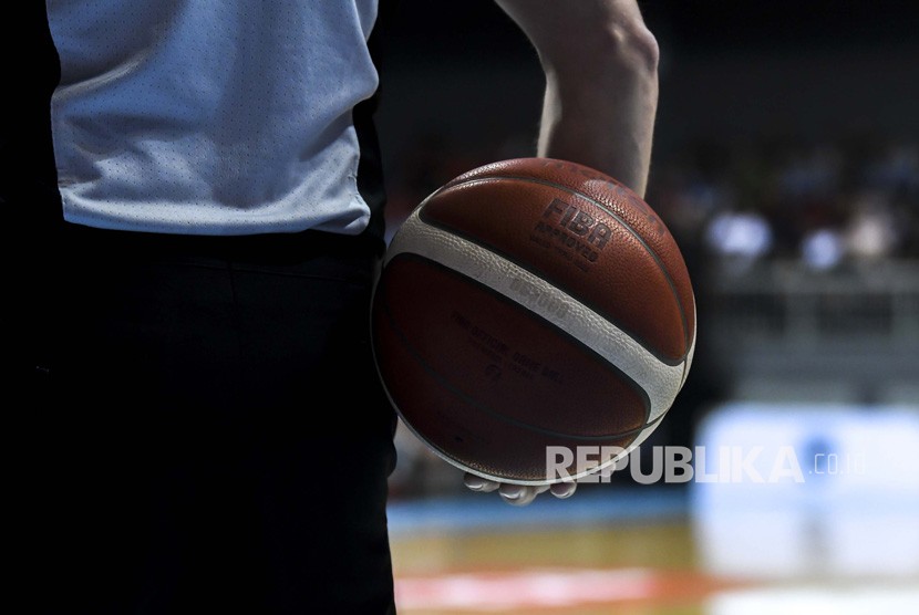 Seorang wasit memegang bola basket pada pertandingan kualifikasi FIBA. Federasi Bola Basket Internasional (FIBA) menjadwal ulang kualifikasi Olimpiade 2020 menjadi tanggal 29 Juni hingga 4 Juli 2021. 