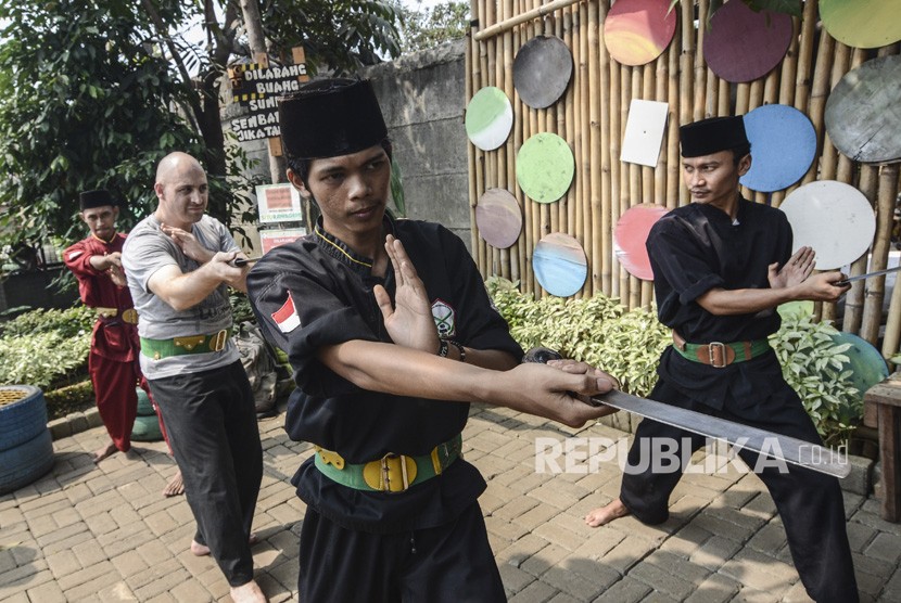 Seorang wisatawan mancanegara (kedua kiri) berlatih Pencak Silat Golok Terbang di Situ Rawa Gede, Bekasi, Jawa Barat, Ahad (8/9/2019).