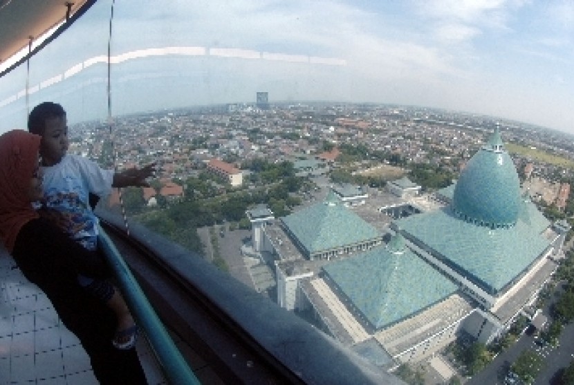 Seorang wisatawan menyaksikan panorama dari atas menara Masjid Al-Akbar Surabaya (MAS), Surabaya, Jawa Timur.