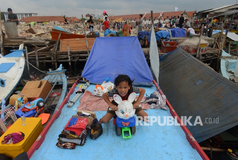 Seororang anak korban bongkaran pemukiman warga kawasan Pasar Ikan yang masih bertahan di atas perahu, Penjaringan, Jakarta Utara, Jumat (15/4). (Republika/ Raisan Al Farisi)