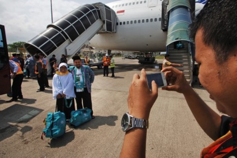 Sepasang calon haji berfoto sebelum pemberangkatan kloter pertama embarkasi Padang, di Bandara Internasional Minangkabau (BIM), Padangpariaman, Sumatera Barat, pada musim haji tahun lalu.