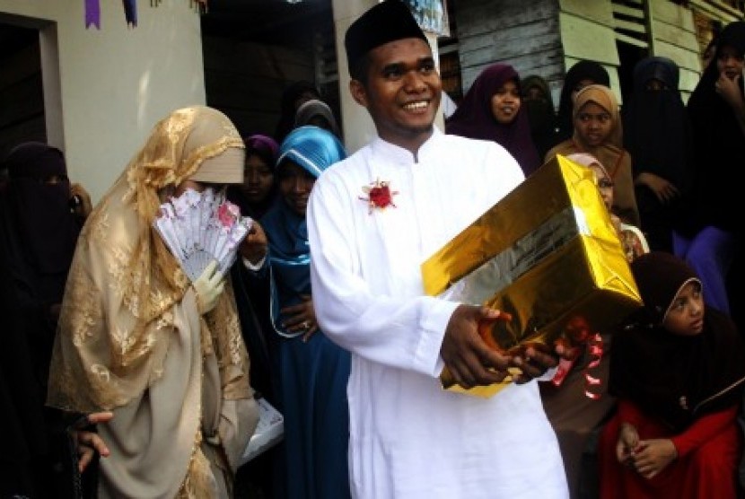 Sepasang pengantin nikah massal keluar dari ruangan nikah dan disambut para keluarga saat mengikuti nikah massal di Pesantren Hidayatullah, Makassar, Sulawesi Selatan, Ahad (1/11).