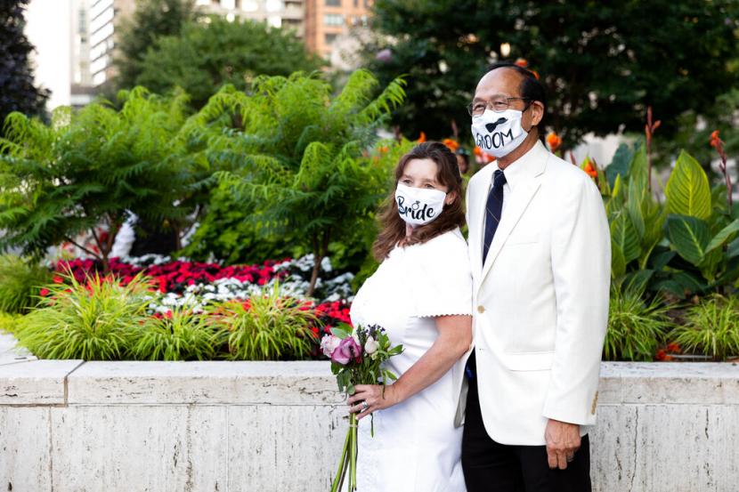 Sepasang suami istri, satu dari lebih 200 pasangan yang pernikahannya dibatalkan atau dikurangi selama pandemi COVID-19, berpartisipasi dalam upacara multikultural simbolis di Damrosch Park, Minggu, 10 Juli 2022, di New York, Amerika Serikat.