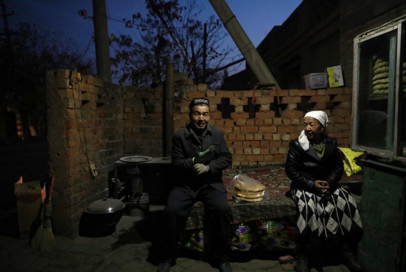 Sepasang suami istri Uighur sedang duduk di depan rumahnya di Desa Turpan, Xinjiang. Editorial media China menyebut pengesahan undang-undang Uighur oleh AS sangat jahat.Ilustrasi.
