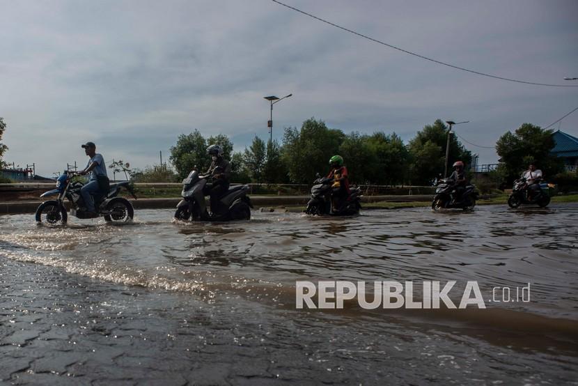 Sepeda motor melintasi banjir rob di kawasan Pelabuhan Perikanan Samudera Nizam Zachman, Muara Baru, Jakarta, Sabtu (6/11/2021). Badan Penanggulangan Bencana Daerah (BPBD) DKI Jakarta memperkirakan puncak musim hujan dan potensi rob di Ibu Kota terjadi pada Januari hingga Februari 2022. 