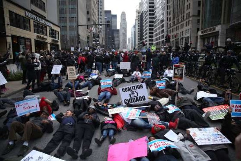 Seratusan demonstran, pada Kamis (24/12), menggelar aksi menentang pembunuhan warga kulit hitam oleh polisi di Michigan Avenue dalam aksi yang disebut Natal Hitam..