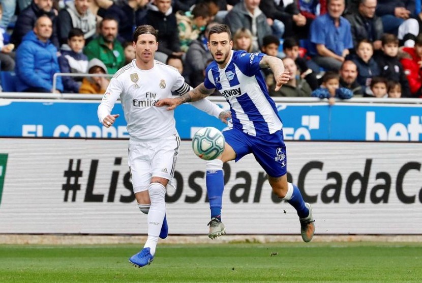 Bek Real Madrid Sergio Ramos berebut  bola dengan Jose Luis Sanmartin dari Deportivo Alaves. Madrid menaklukkan Alaves 2-1 dalam lanjutan Liga Spanyol.