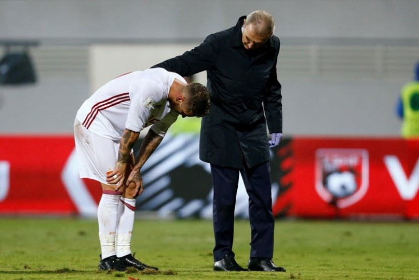 Sergio Ramos (kiri) menahan sakit saat membela Spanyol melawan Albania, Senin (10/10)