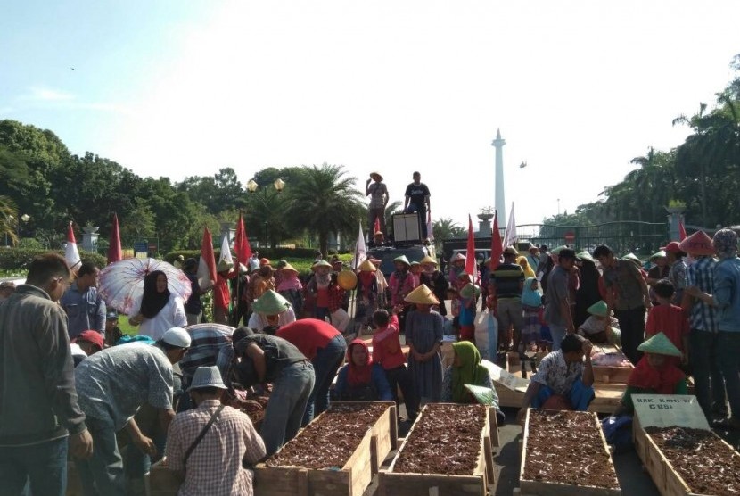 Serikat Tani Teluk Jambe gelar Aksi Kubur Diri dalam rangkat memperingati Hari Buruh di Monas, Jakarta Pusat, Senin (1/5). 