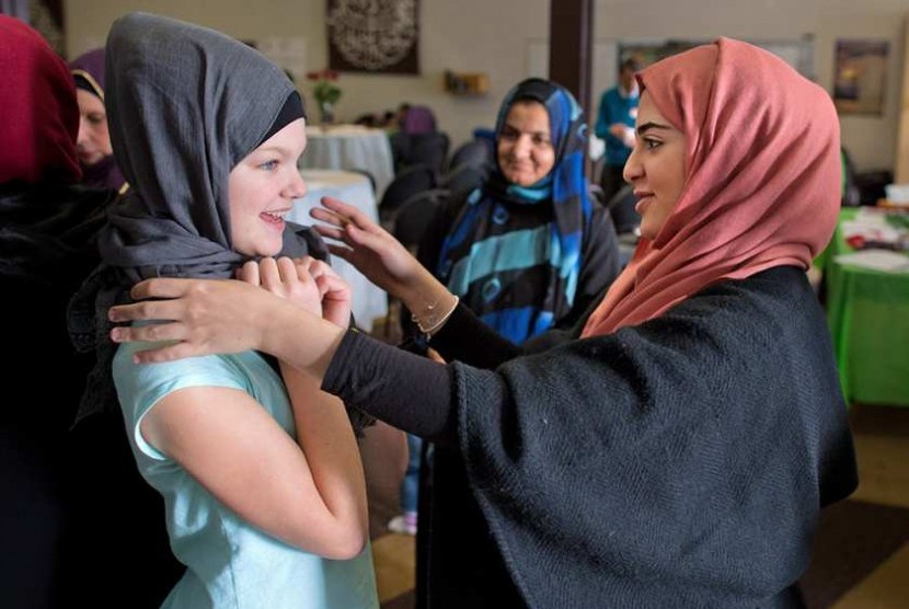 Serina Hammoud membantu Eliza Stewart (12) mencoba hijab dalam Open House di masjid di Ranchlands, Ahad (13/11). Acara yang digagas Islamic Association of Northwest Calgary bertujuan membina hubungan ebih akrab antara jamaah dengan komunitas sekitar.