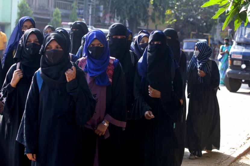 Serombongan siswa perempuan India berjalan menuju sekolah mereka di Udupi, India, Senin (7/2/2022). Pelajar India yang menggunakan jilbab dilarang memasuki ruang kelas mereka.