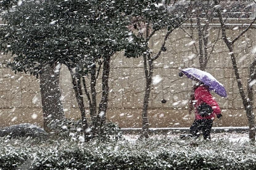  Seseorang berjalan melewati hujan salju lebat di barat daya kota Gwangju, Korea Selatan, 17 Desember 2022. 