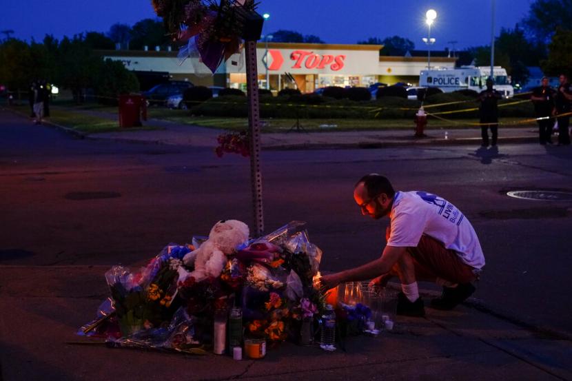Seseorang memberikan penghormatan di luar lokasi penembakan di sebuah supermarket, di Buffalo, New York, Ahad 15 Mei 2022.